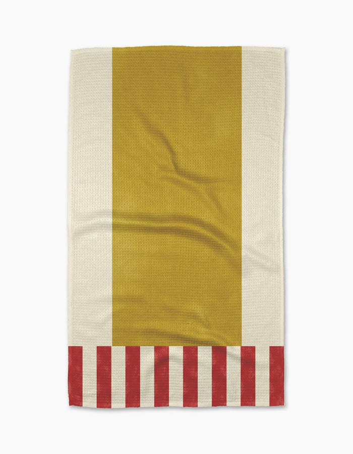 The Geometry Striped Heart Yellow tea towel features a bold vertical yellow center, off-white sides, red and off-white stripes along the bottom, and is crafted from sustainable recycled materials.