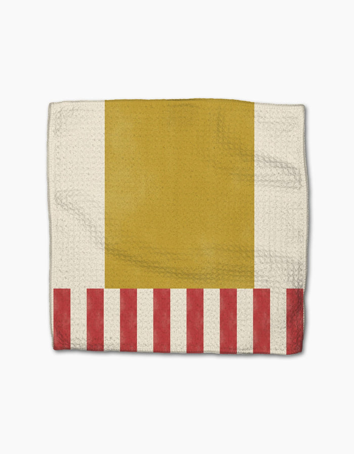 Geometry’s Striped Heart blanket is made with recycled materials and features an off-white background, a large yellow rectangle on top, and red and white stripes at the bottom, resembling a box of French fries.