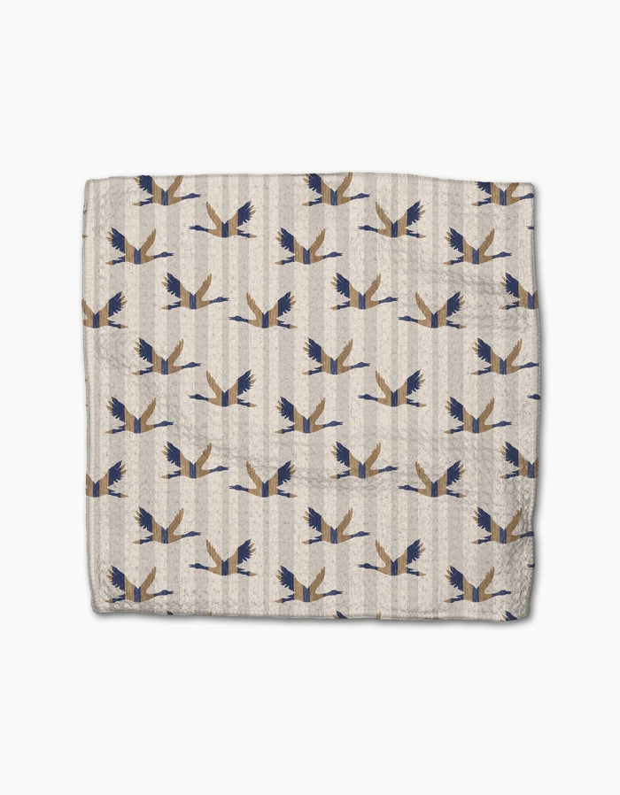 The Striped Nautical Birds cloth napkin by Geometry features a folded beige design with blue and brown stylized birds, crafted from recycled materials and set against a subtle striped background.