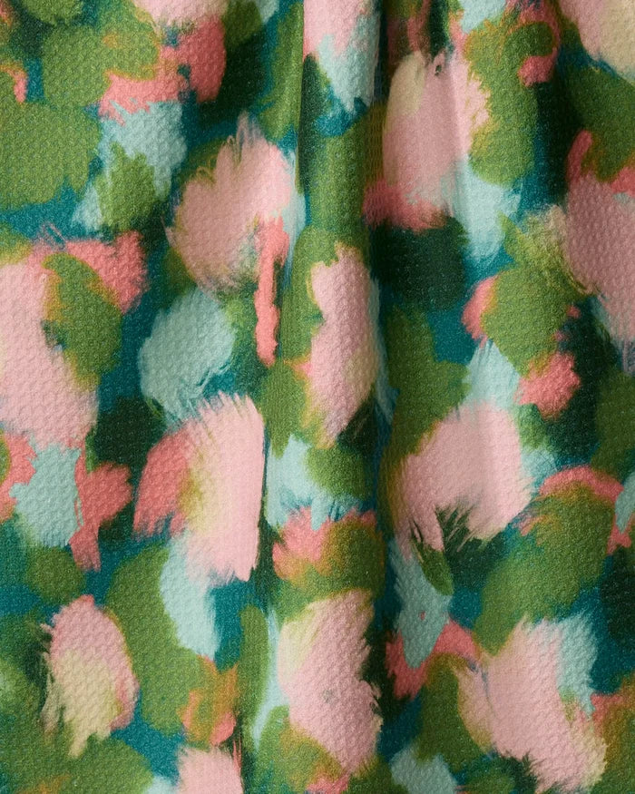 Shelley Smith’s Stroke of Genius tea towel features an abstract green, pink, blue, and cream pattern with textured ridges. Made from recycled materials, this ultra-absorbent towel is perfect for kitchen use.