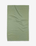 The Kailee Wright Sugar kitchen towel is green, rectangular, eco-friendly, with a waffle texture and small white polka dots, shown flat with gentle wrinkles.