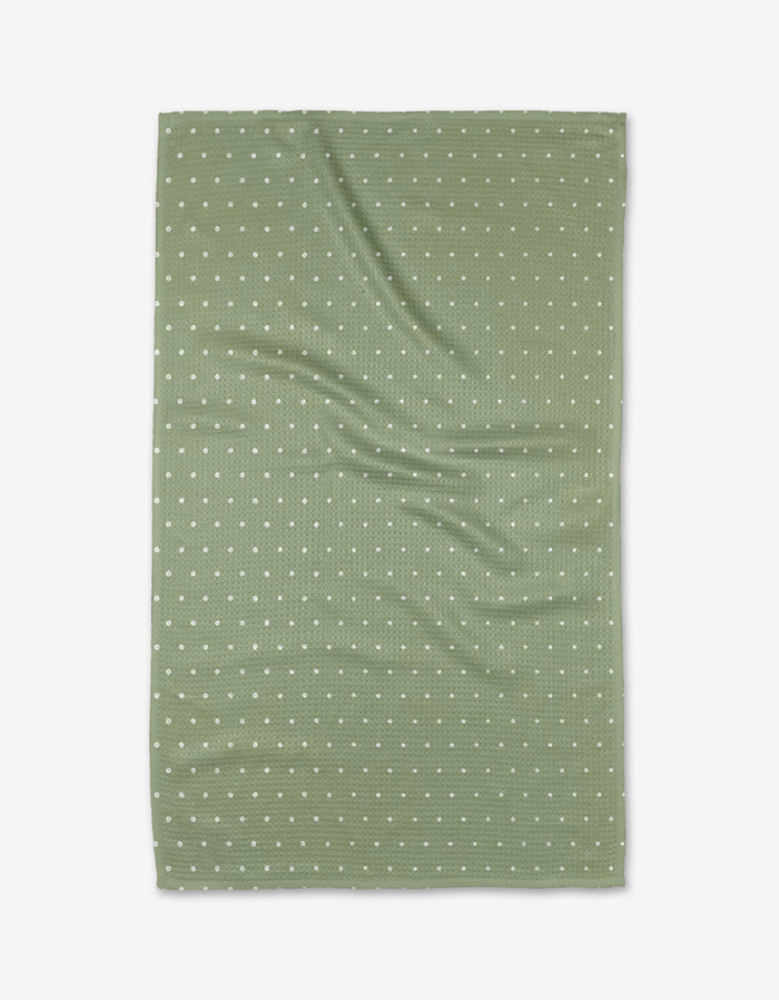 The Kailee Wright Sugar kitchen towel is green, rectangular, eco-friendly, with a waffle texture and small white polka dots, shown flat with gentle wrinkles.