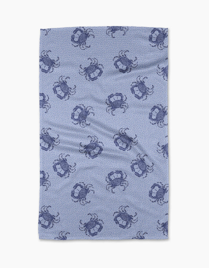The Geometry Summer Crabs Tea Towel features dark blue crabs on a light blue, subtly dotted background. Made from eco-friendly material, it has a slightly wrinkled look and is shown on a white surface.