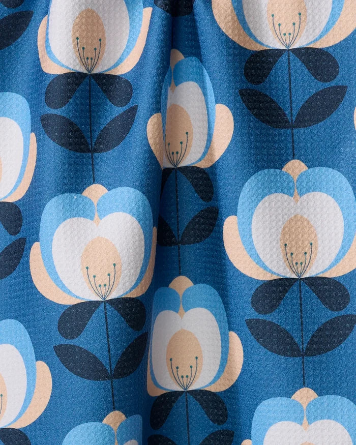 Close-up of the Blissful Flamingo Summer Florals ultra-absorbent towel, showcasing a textured blue background with a repeating pattern of stylized blue, cream, and black flowers.