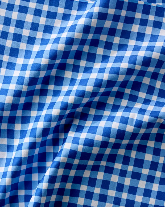 A close-up of Summer Plaid by Danelys Sidron—blue and white checkered fabric with wavy folds, ideal for eco-friendly dinner napkins that blend style and sustainability.