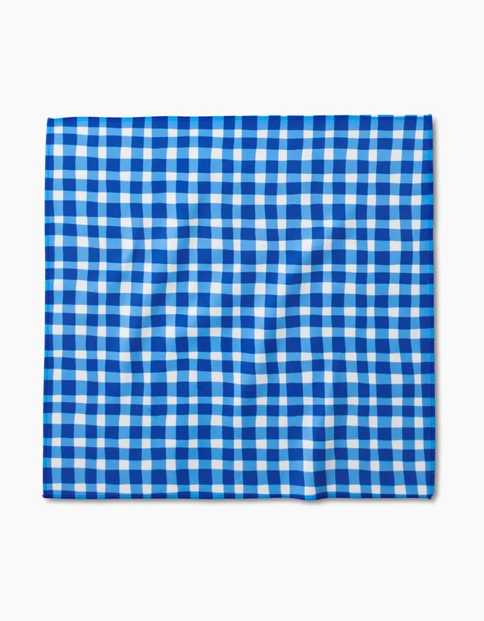 The Danelys Sidron Summer Plaid square dinner napkin features a blue and white gingham pattern, crafted from Geosuede fabric with post-consumer recycled materials for an eco-friendly touch.
