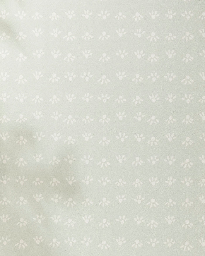 Sun Bursts by Anee Shah features a light green background with evenly spaced small white paw prints and subtle left-side shadows—ideal for a recycled yoga towel.