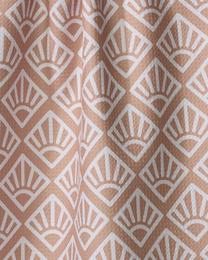 Sunrise Mosaic by Rosa Kichline features beige fabric with a repeating white art deco fan pattern in diamond shapes. Its slightly folded texture makes this absorbent tea towel a charming and functional addition to any kitchen.