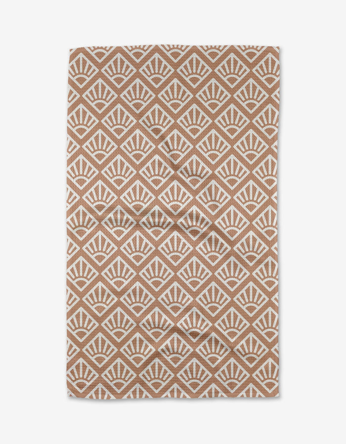 The Rosa Kichline Sunrise Mosaic is a brown and white rectangular rug with a repeating geometric fan pattern in a diamond grid. Made from recycled materials, its symmetrical design offers a modern, eco-friendly look.