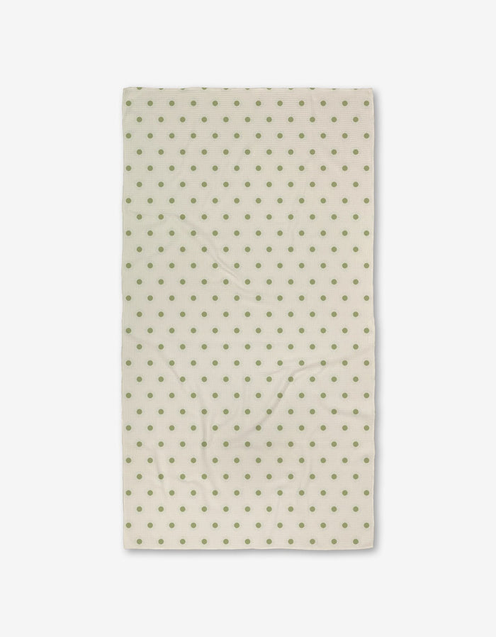 The Sunshine Glow by Danelys Sidron is a cream-colored rectangular cloth with evenly spaced green polka dots, made from recycled materials, displayed flat against a white background.