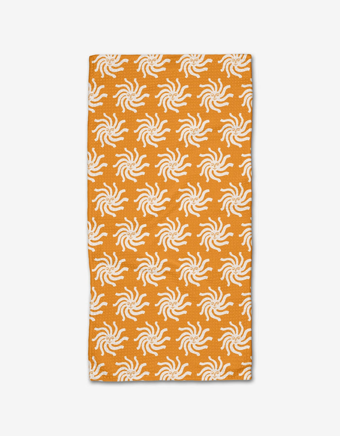 The Kayla Ann Sunshine Smile bar towel is a rectangular orange towel made from Geoweave fabric, featuring an evenly spaced repeating pattern of white sun-like shapes, shown on a plain white background.