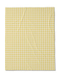 The Geometry Sunspread is a square fabric with a yellow and white gingham check pattern with small, even squares. Made from recycled materials, it features a lightly wrinkled texture.