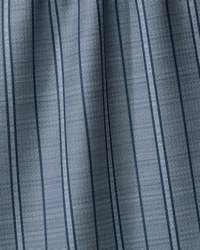 Close-up of Super Stripe - Navy by The Buy Guide: gray fabric with vertical navy pinstripes and subtle horizontal texture. This absorbent dish towel is slightly gathered, forming gentle folds for a formal, tailored look.