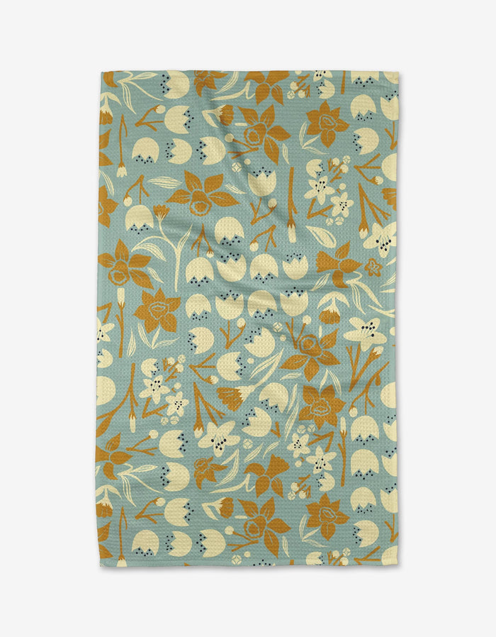 The Swedish Cherry Blossoms tea towel by Elisabeth Wing features cream and brown retro flowers and leaves on a blue background. Made from recycled materials, it blends vintage style with eco-friendly design.