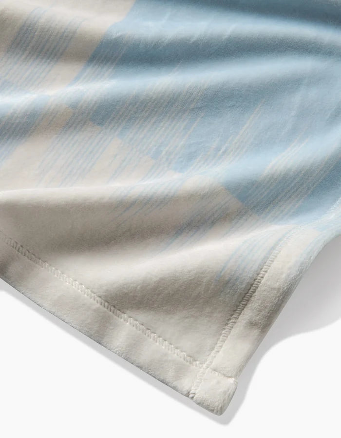 Close-up of Sweet Checks by Geometry, featuring blue and beige abstract patterns on a smooth, lightweight fabric with a stitched hem—ideal for sustainable bedding crafted from recycled materials.