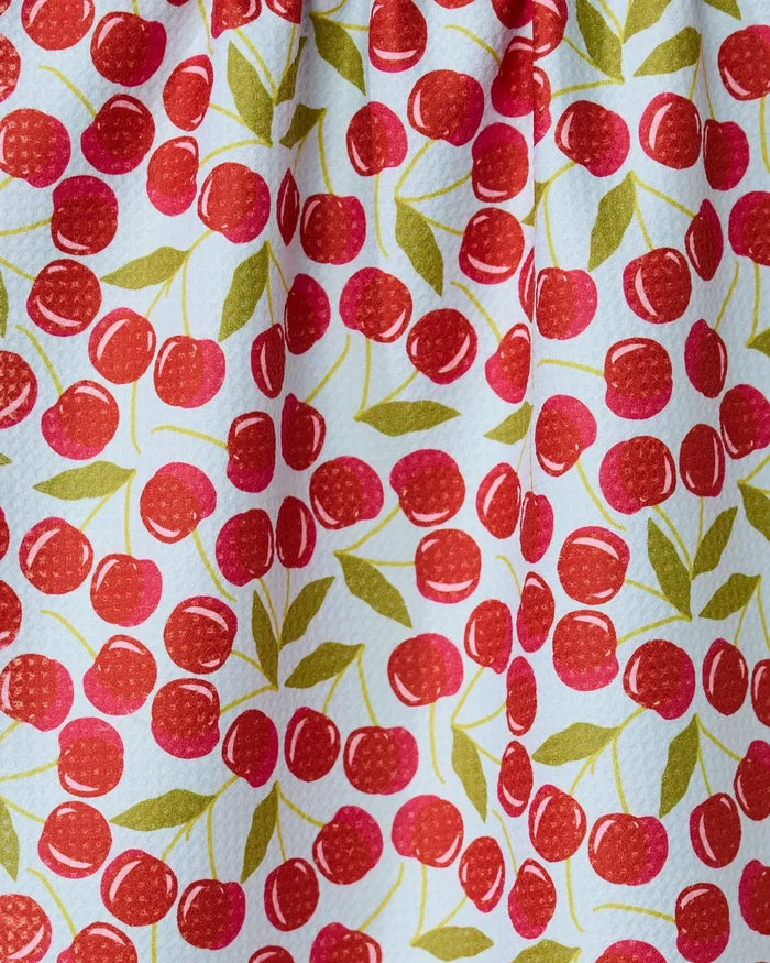 The GEOMETRY Sweet Cherry towel features a colorful cherry pattern with red cherries and green leaves on white. Quick-drying and slightly textured, it’s gathered at the top, perfect for adding a cheerful touch to your kitchen.