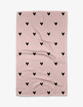 The Kailee Wright Sweet Hearts blanket features a light pink background with evenly spaced black hearts, made from ultra-absorbent Geoweave fabric and shown laid flat with slight wrinkles.