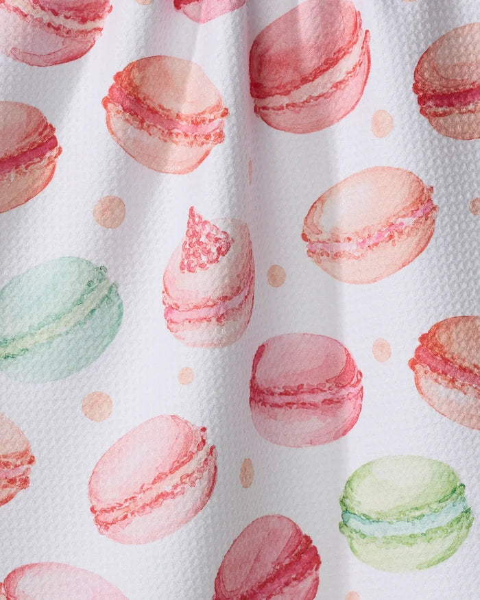 Seventies Retro Flowers by Claire Iglesias: a watercolor illustration featuring pink, green, and peach macarons scattered on a white recycled kitchen towel with small dots between them.