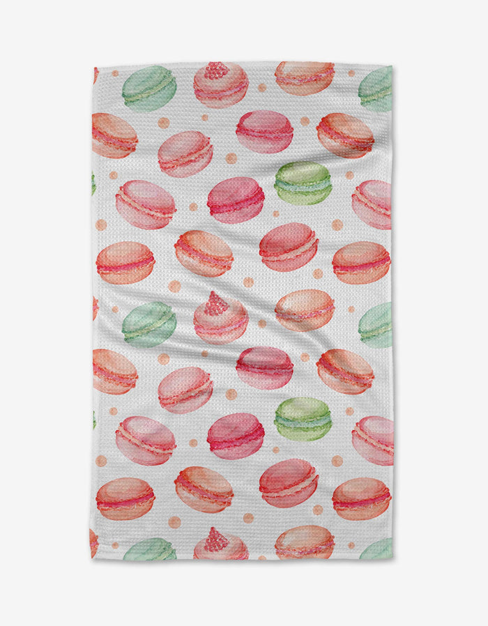 The Elena Fay Sweet Macarons Tea Towel features a watercolor pattern of pink, green, and orange macarons with dots on white Geoweave fabric for softness and absorbency.