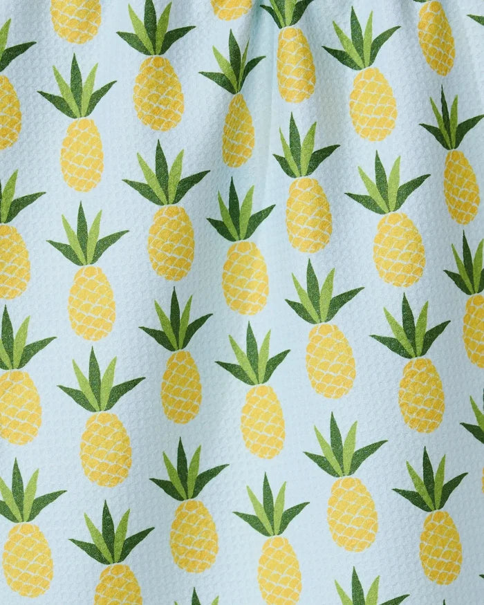 The GEOMETRY Sweet Pineapple tea towel features a repeating pattern of yellow pineapples with green leaves on a light blue textured background, adding a cheerful touch to your kitchen décor.