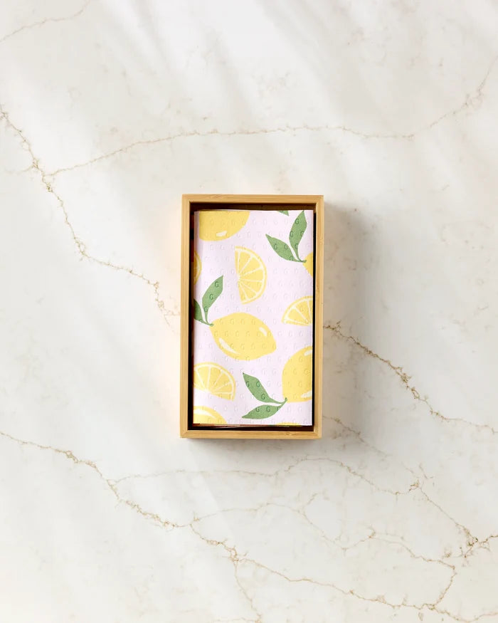 A GEOMETRY Sweet Summer Mix 1 rectangular wooden box holds reusable paper towels with a lemon and leaf pattern, displayed on a subtly veined light marble surface.