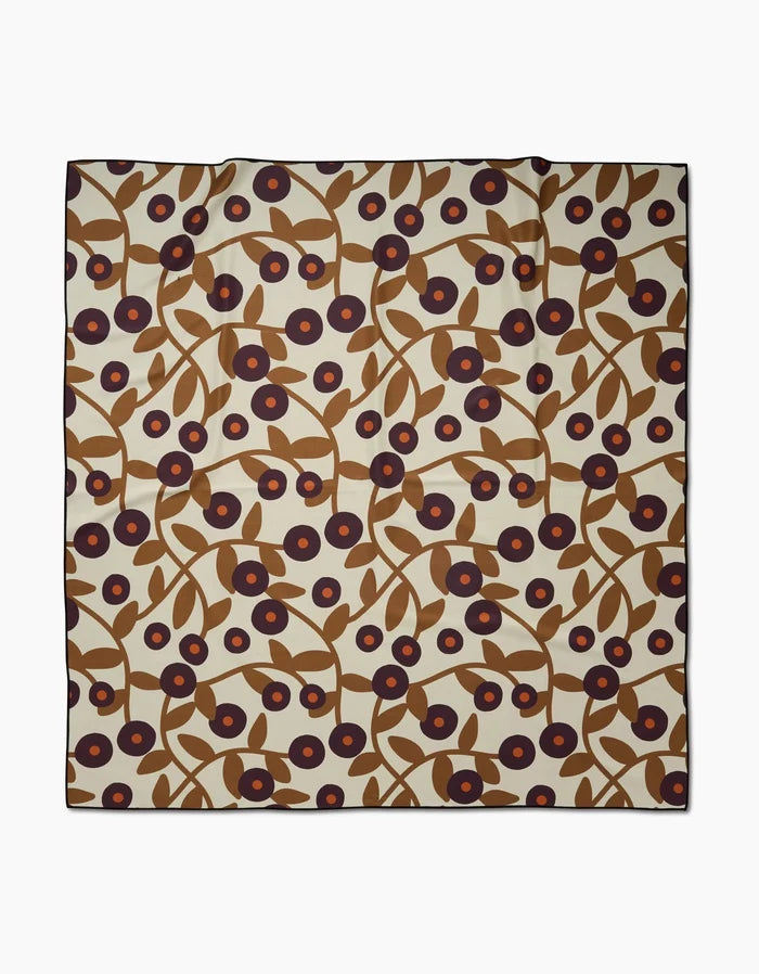 The Swirling Vines square scarf by Lizzie Clark features a cream background with brown branches, leaves, and dark red flowers with navy centers—crafted from soft recycled beach blanket material.
