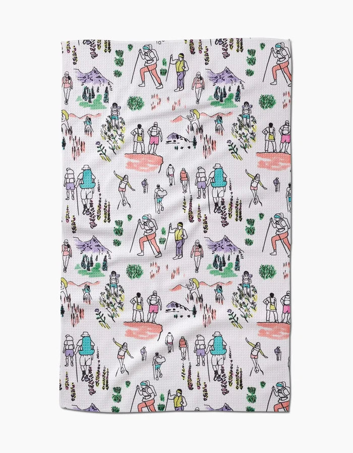 The Elisabeth Wing Take A Hike tea towel features a Geoweave fabric with colorful illustrations of hikers, mountains, trees, bushes, and trails on a white background, creating an outdoor adventure theme.
