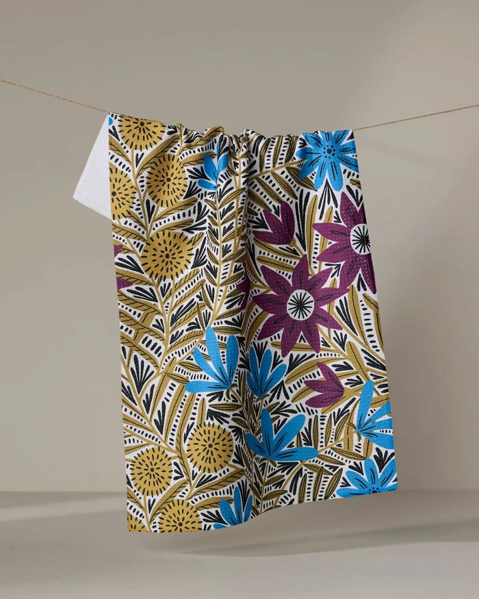 The Amy MacCready Teagan Dark Maroon tea towel, ultra-absorbent and vibrant, hangs on a clothesline against a plain light background.