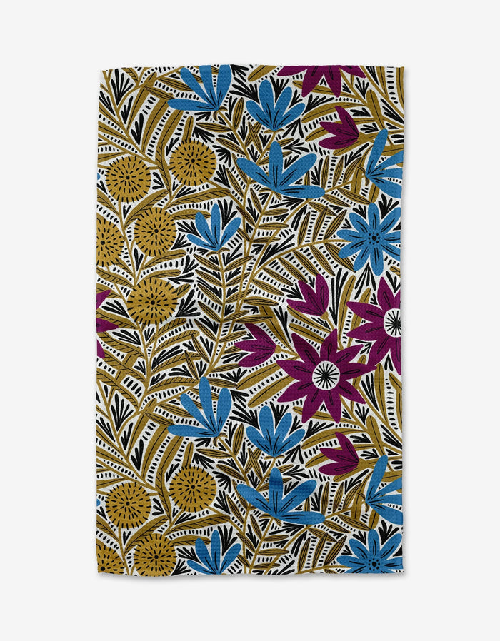 The Teagan Dark Maroon tea towel by Amy MacCready is made from Geoweave™ fabric and features a botanical pattern with blue, mustard yellow, and magenta flowers, black and white leafy branches on a crisp white background.