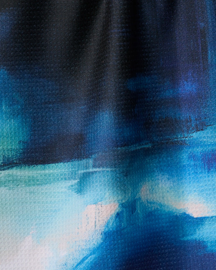 The Ocean Between Us" by Jennifer Janesko is an abstract painting with dark blue, turquoise, and white brushstrokes blending like a recycled-material tea towel, featuring dynamic light and shadow for visual interest.