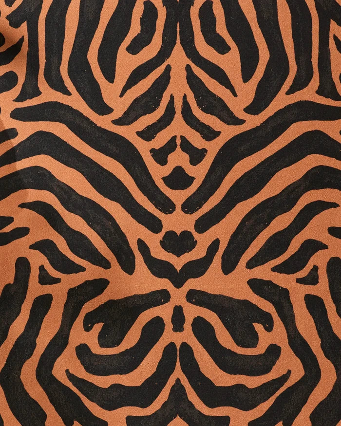 Close-up of the GEOMETRY Tiger yoga towel features a black and orange tiger stripe pattern on a textured, slip-resistant surface, highlighting its symmetrical, abstract design.