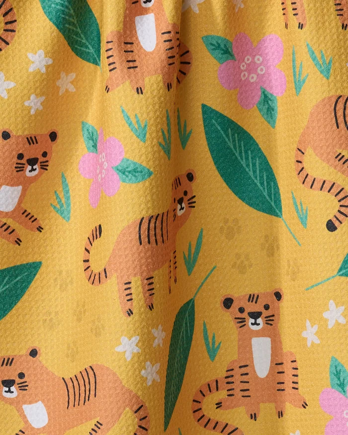 The "Tigers" kitchen towel by Genna Blackburn features playful cartoon tigers, green leaves, and flowers on a yellow background—perfect for brightening up your space.