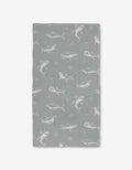 The Toothy Tales Luxe Bath Towel by Janna Sue Design features gray and white sharks with starfish on a light gray background. Made with Geoweave technology for exceptional softness and absorbency. Displayed against a plain white backdrop.