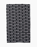 The GEOMETRY Touchdown tea towel is made from recycled materials and features TOUCHDOWN! in bold white uppercase letters, printed repeatedly across its black Geoweave fabric in a striking horizontal pattern.