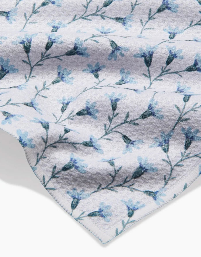 A close-up of the Trailing Flowers in Blue Bar Towel by Teri the Butter, made from recycled materials and featuring a delicate blue floral pattern with small blue flowers and green stems.