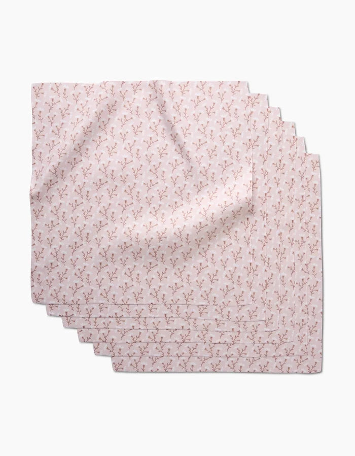 Six “Trailing Flowers in Pink” Dinner Napkins by Teri the Butter, featuring a subtle floral pattern on soft Geosuede fabric, are neatly stacked and slightly fanned out on a white background.