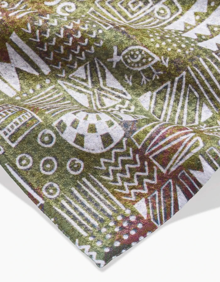 The Taryn Brennan Tribal Symbols Bar Towel showcases white geometric and tribal patterns—including zigzags, circles, and an eye—on a green and brown Geoweave fabric, offering an eco-friendly touch for your bar.