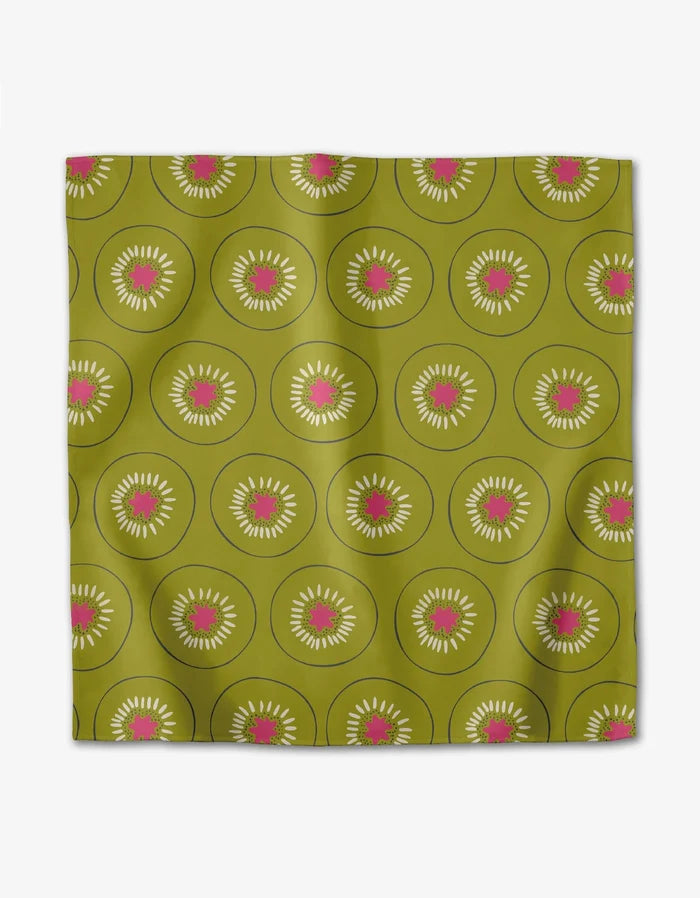 The Tropical Fruit scarf by Lizzie Clark is a green Geosuede square featuring a repeating kiwi slice pattern with white seeds and pink centers on an olive background, crafted from recycled materials.