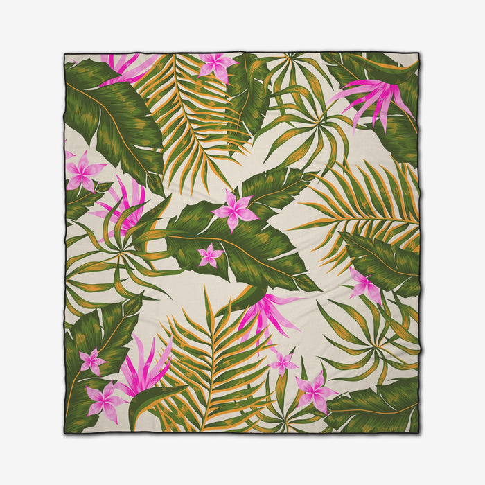 The GEOMETRY Tropical Jungle is a square, quick-drying beach blanket featuring an all-over lush design with green palm leaves and pink flowers on a cream background.