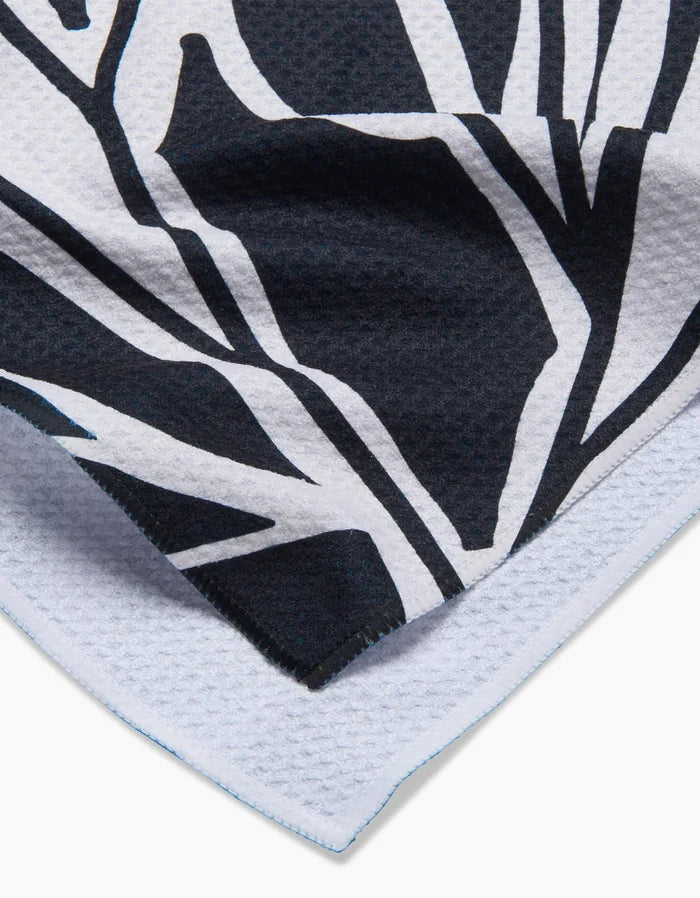 Close-up of Ash Cascades Twilight Plant kitchen towel, featuring a black and white abstract botanical pattern on eco-friendly, textured fabric with neatly stitched edges.