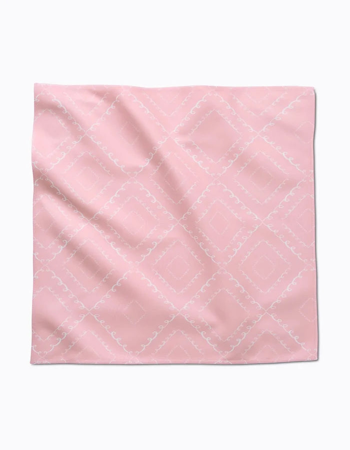 The Elena Fay Twirls is a square, light pink cloth napkin featuring a subtle white diamond and swirl pattern, shown laid flat with slight wrinkles.