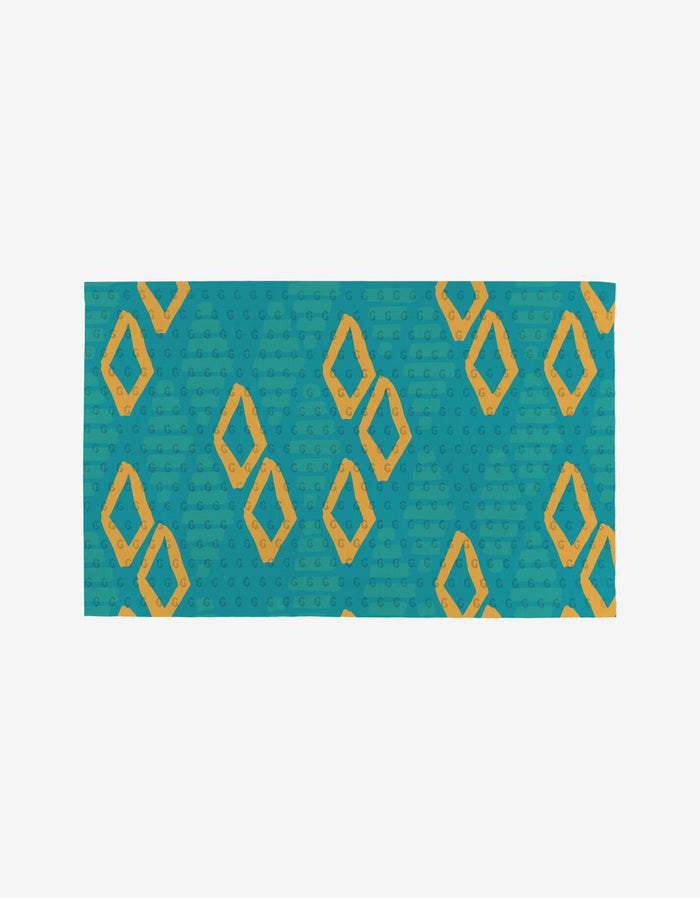 The Sareka Unique Unique mat is rectangular, teal, and features yellow-orange diamonds with circular dots, crafted from eco-friendly post-consumer recycled materials.