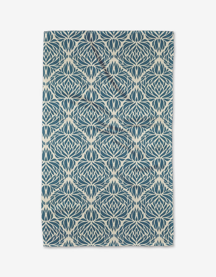 The Untangled tea towel by Rebecca Woolbright features a detailed blue and white geometric floral pattern on white, displayed flat with gently uneven edges.