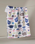 The "Utensils" tea towel by Cottonflower Studio is made from recycled materials and features colorful kitchen items in blue, pink, green, and brown on a neutral background. Ultra-absorbent and stylish—perfect for any kitchen.