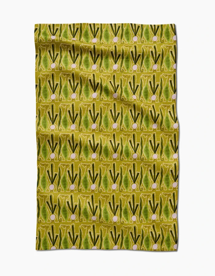Veg on Parade by Lizzie Clark is a patterned Geoweave fabric made from recycled materials, featuring rows of abstract green and yellow shapes with pink circular accents in a repeating geometric design on a yellow background.