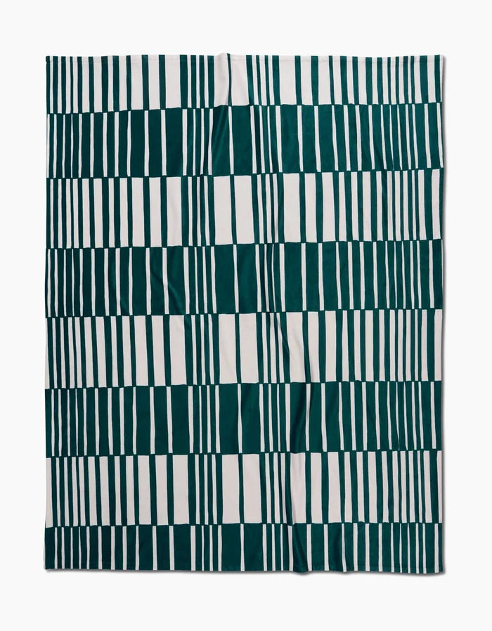 The Verdelia by Geometry is a square textile with a geometric pattern of vertical green and white rectangles in rows, forming a checkered look. Made from recycled materials, it appears slightly wrinkled and is shown flat on a white background.