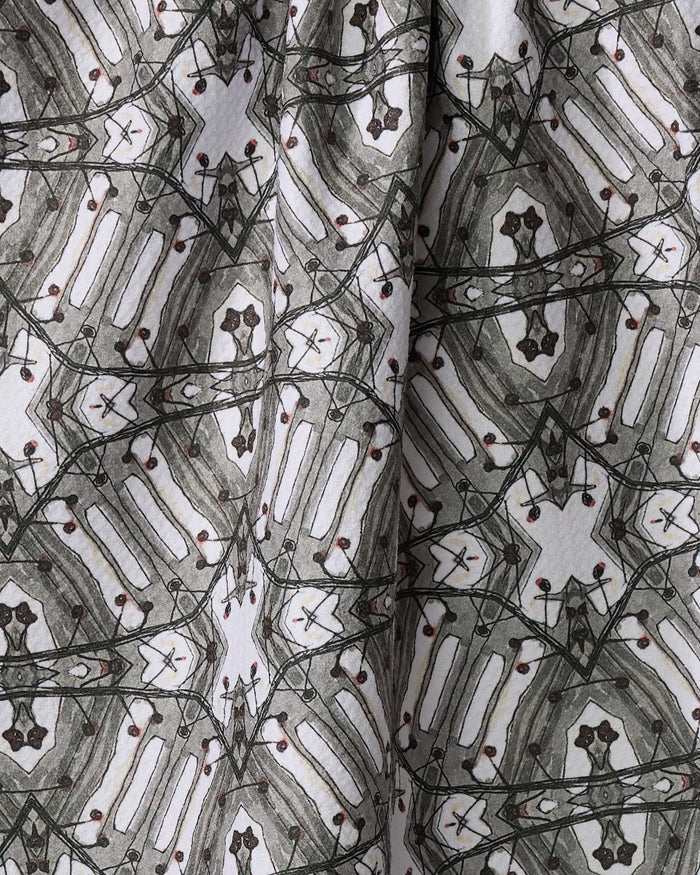 A close-up of the Walk The Line Shimmy by Katherine Berkeley, a recycled kitchen towel with symmetrical black, gray, and brown geometric lines on white. Fabric folds enhance depth and texture in this ultra-absorbent design.