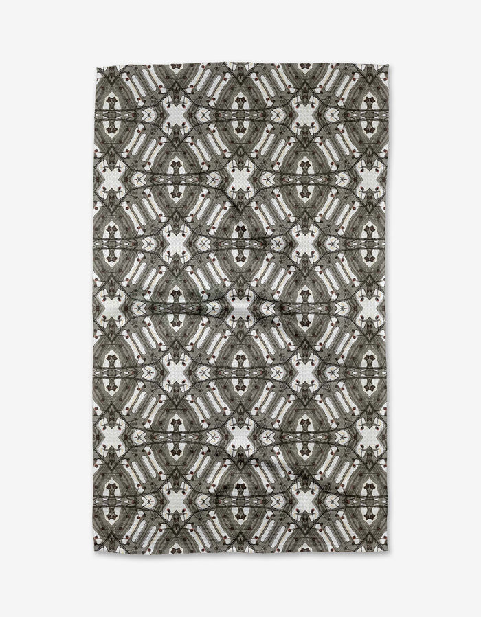 The Walk The Line Shimmy rug by Katherine Berkeley features a symmetrical geometric pattern in gray, black, and white, offering an intricate and stylish accent reminiscent of ornate dish towel designs.