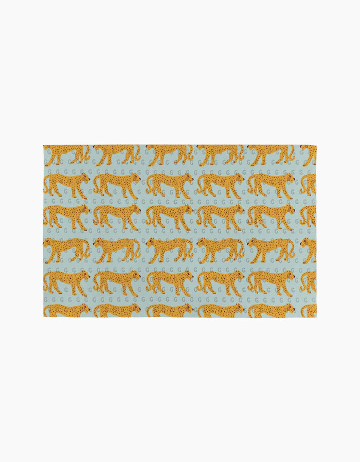 The Walking Cheetah rug by Jasmine Blooms Designs is a light blue rectangular rug with orange cheetahs walking left and decorative swirls—an ideal eco-friendly accent for homes that use reusable paper towels.