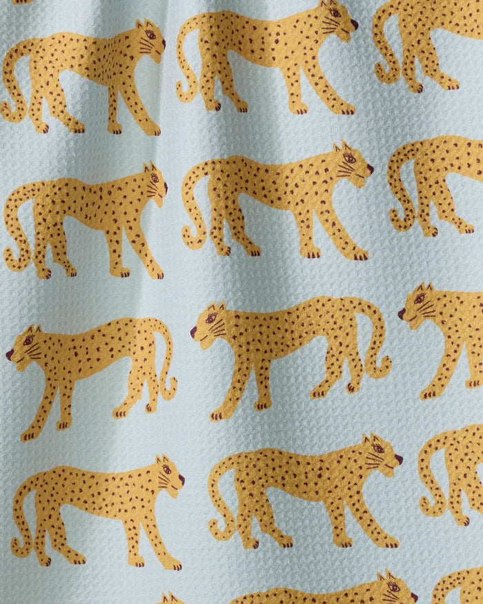 Walking Cheetah" by Jasmine Blooms Designs features rows of stylized yellow cheetahs with black spots on a light blue textured background—an eco-friendly tea towel for a vibrant, sustainable kitchen accent.
